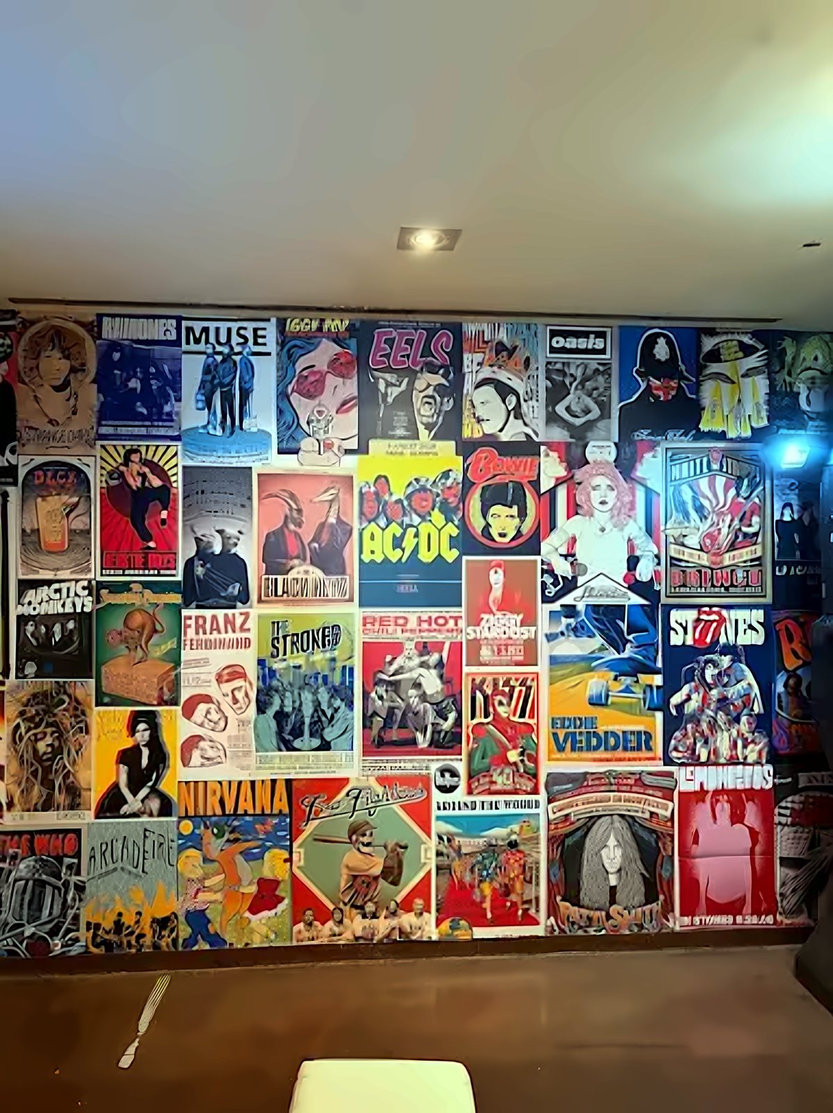 Pared del local forrada de carteles de grupos: Ramones, Oasis, Arctic Monkeys, The Strokes, Nirvana, AC/DC y muchos más